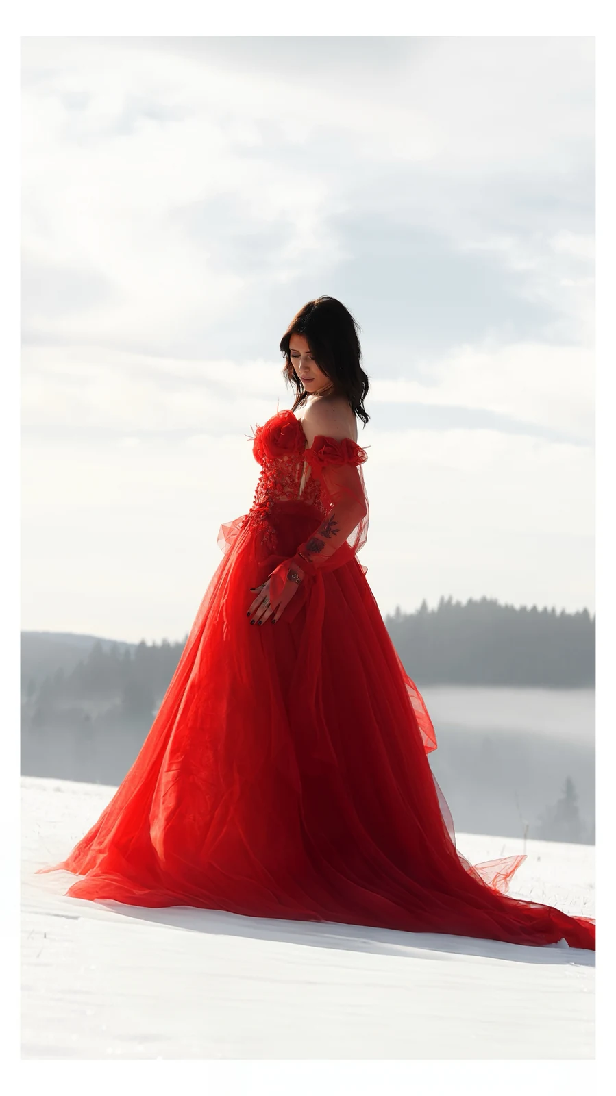 Mariée en robe rouge dans un paysage enneigé
