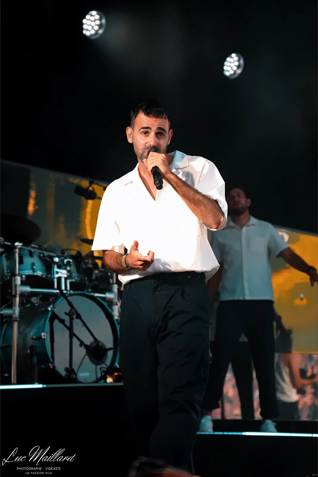 Chanteur au micro devant la batterie
