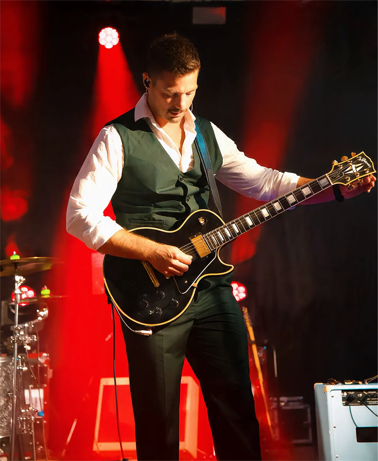 Guitariste et sa Les Paul sous les projecteurs rouges