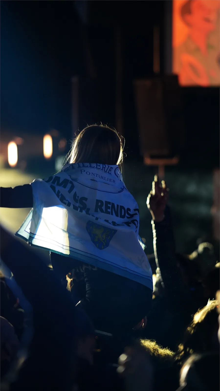 Spectatrice portant un drapeau au milieu du public