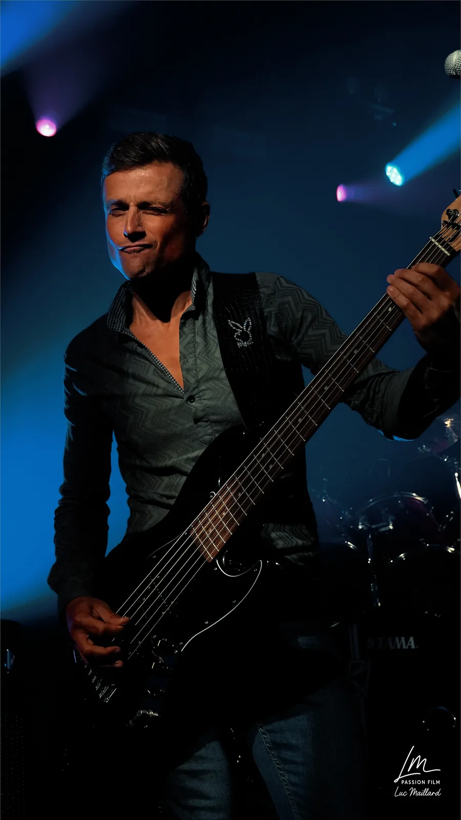 Bassiste sur scène en lumière bleue