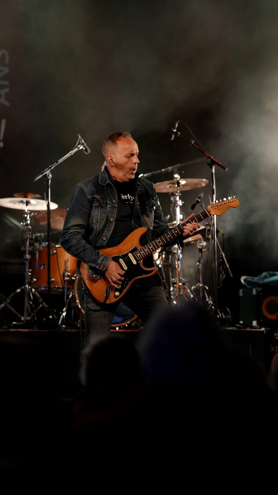 Guitariste sur scène vu depuis le public