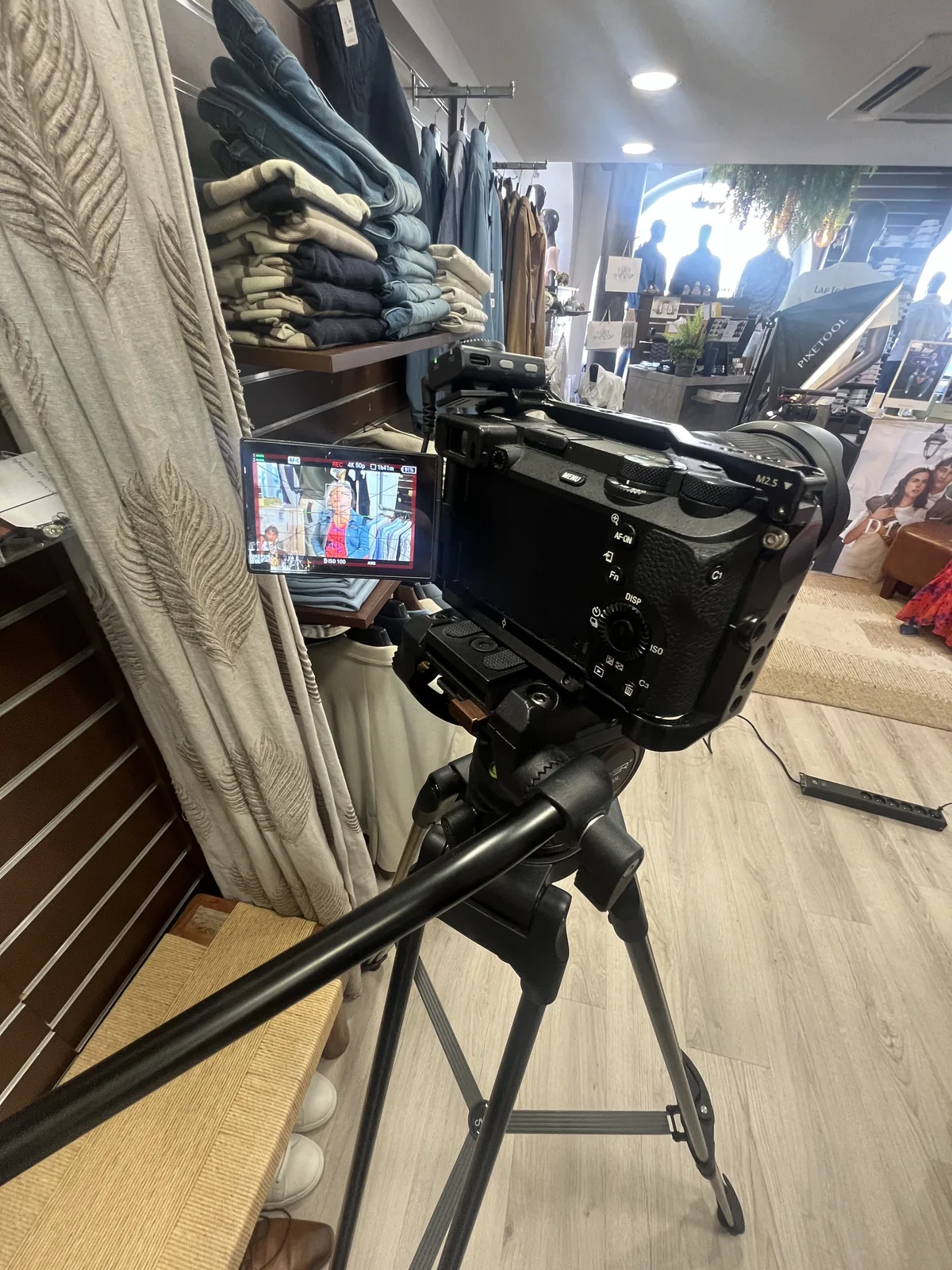 Caméra sur trépied et retour vidéo pendant un tournage en boutique